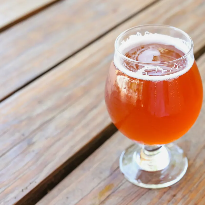 Stock photo: a glass of beer on an outdoor timber table