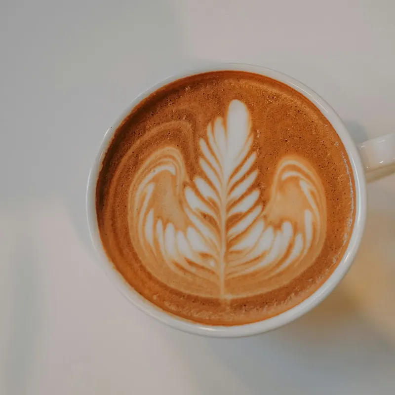 Stock photo: a coffee on a pale café table in soft daylight