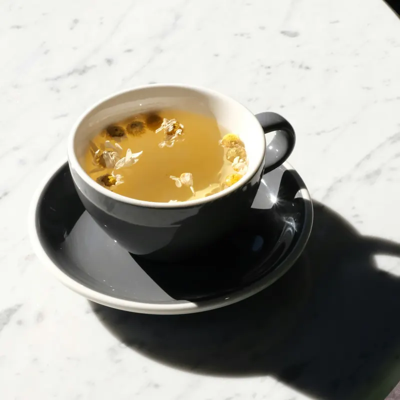Stock photo: a cup and saucer on a sunlit marble table