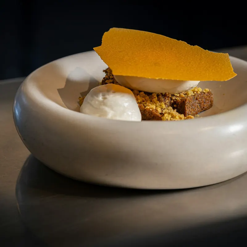 Stock photo: a dessert in a stoneware bowl on a dark steel bench