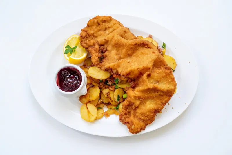 Nano Banana Pro output: the same schnitzel plate on a plain white background, seen from higher up